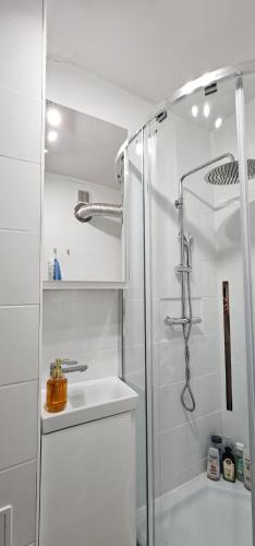 a white bathroom with a shower and a sink at Mieszkanie dwupokojowe z balkonem, blisko parku in Jastrzębie Zdrój