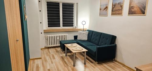 a living room with a green chair and a table at Mieszkanie dwupokojowe z balkonem, blisko parku in Jastrzębie Zdrój