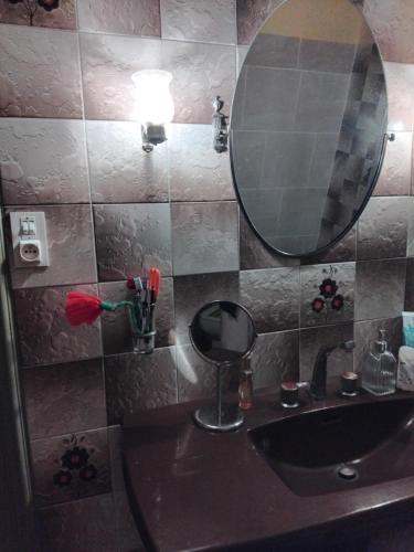 une salle de bain avec un lavabo et un miroir dans l'établissement Esyom's, à Coulonces