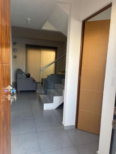 a hallway with stairs and a couch and a door at Casa ensueño in Los Algodones