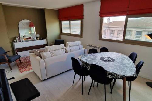 un salon avec un canapé blanc et une table dans l'établissement Le Ciel Bleu Clim Wifi Garage, à Aix-en-Provence