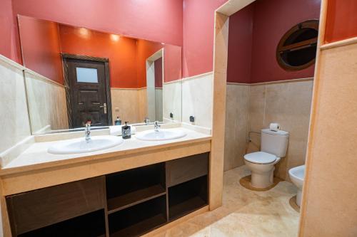 a bathroom with two sinks and a toilet at Konouz Palace in Marrakech
