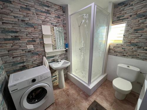 a bathroom with a washing machine and a sink at Villa Garruchal in El Caracolero