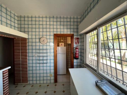 a kitchen with a refrigerator in a room with windows at Villa Garruchal in El Caracolero
