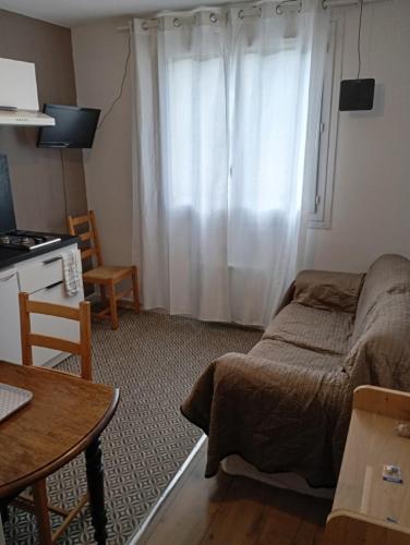 un salon avec un lit et une fenêtre dans l'établissement Évasion Hébergement, à Allevard