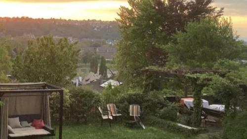 a garden with chairs and a couch and a gazebo at Über den Dächern von Koblenz - Aussichts-Wohnung Naturpark Rheinblick, ruhig, zentrumsnah, Sport-Pool in Koblenz