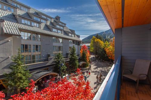 a view from a balcony of a building with red flowers at Village Gate House by Whiski Jack in Whistler