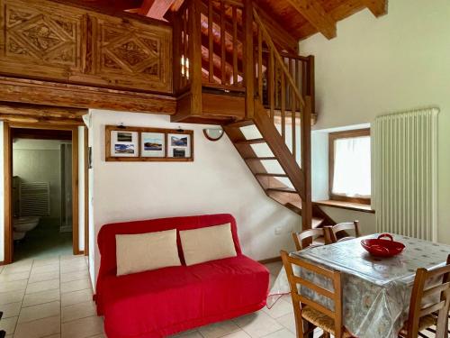 a living room with a red couch and a table at Abri Vigneroisa appartamento Miserin in Champorcher