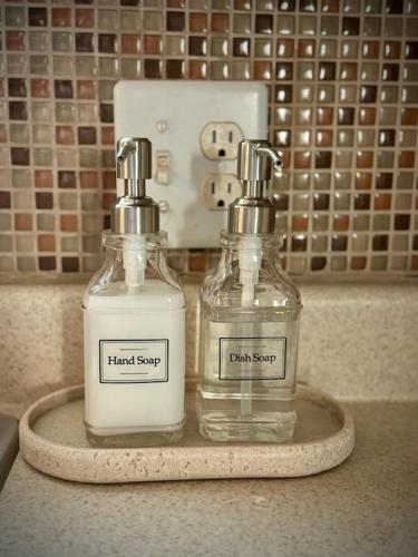 two bottles of hand soap on a tray on a counter at The Sunset Cottage - Wyoming by Primo Management in Rock Springs