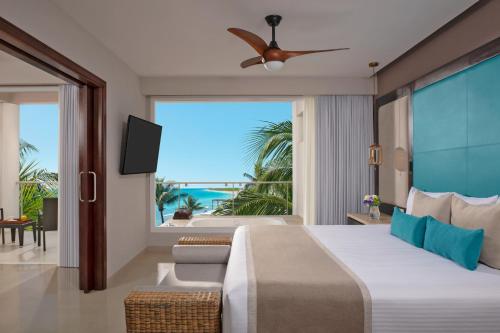 a bedroom with a bed and a view of the ocean at Dreams Jade Resort & Spa - All Inclusive in Puerto Morelos