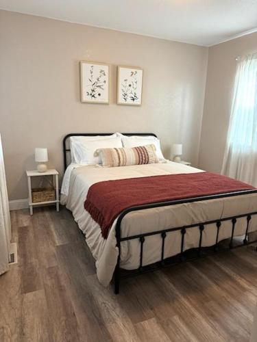 a bedroom with a bed with a red blanket at The Sunset Cottage - Wyoming by Primo Management in Rock Springs
