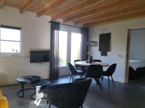 a living room with a table and chairs at De Heide in Wijnjewoude