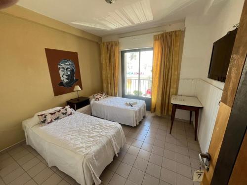 a hotel room with two beds and a window at Hotel Urbano Ventia in Comodoro Rivadavia