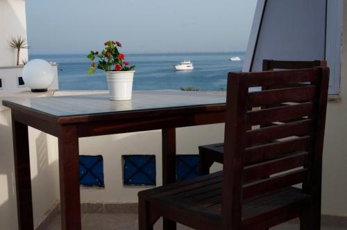 a wooden table with a chair and a table with a window at Elaria Hotel Hurgada in Hurghada