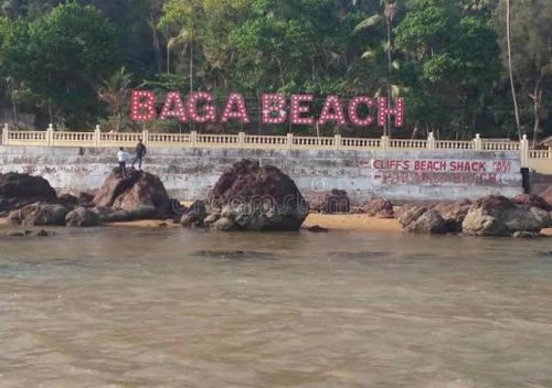 a person standing on a rock near the water at 2 BHK luxury apartment in Calangute beach Saldana in Calangute