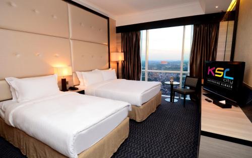 a hotel room with two beds and a television at KSL Hotel & Resort in Johor Bahru