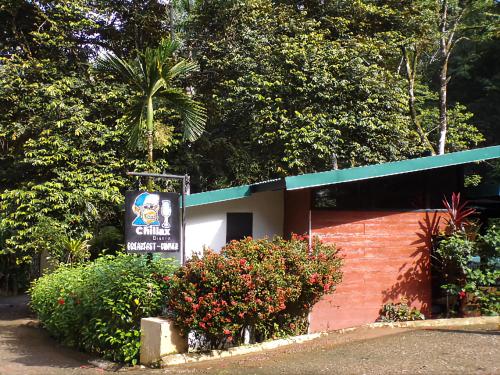 a sign in front of a building with bushes at Riverside Villas in Manuel Antonio