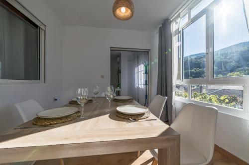 a dining room with a table and a large window at Casa LAS TORRES in Dúdar
