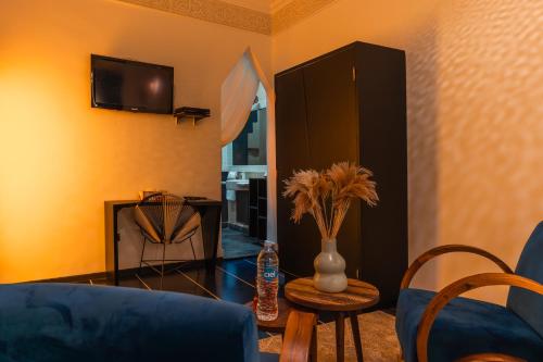 a living room with a blue couch and a table at Riad L'ECOLE in Marrakech