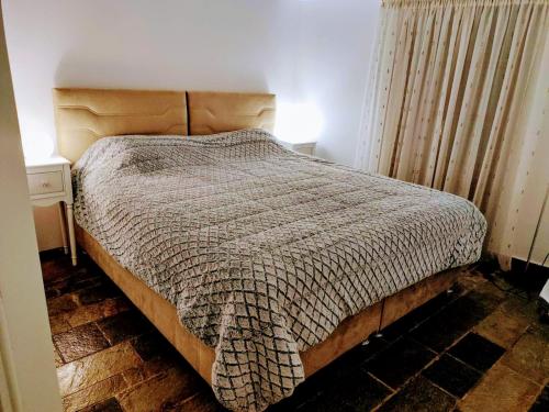 a bedroom with a bed with a wooden headboard at Elizabeth's house 2 Λιβάδι Αράχωβας in Kalívia