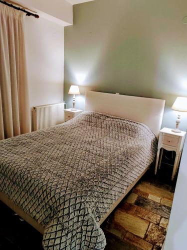 a bedroom with a bed and two lamps on tables at Elizabeth's house 2 Λιβάδι Αράχωβας in Kalívia