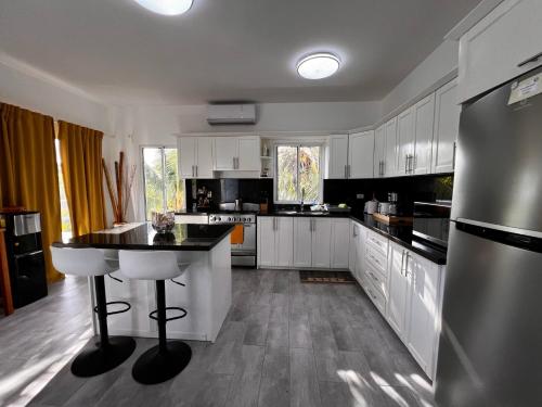 a kitchen with white cabinets and a black counter top at Apartamento Carey in Cabrera