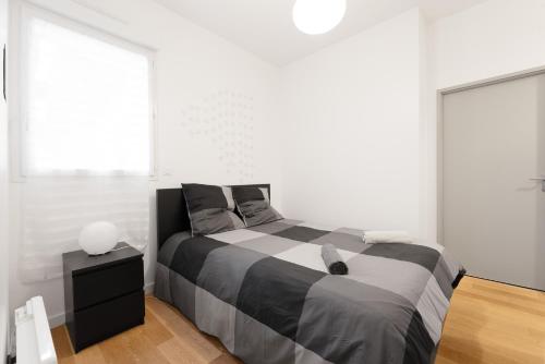 une chambre avec un lit noir et blanc et une fenêtre dans l'établissement Appartement aux coeur des Chalets, à Toulouse
