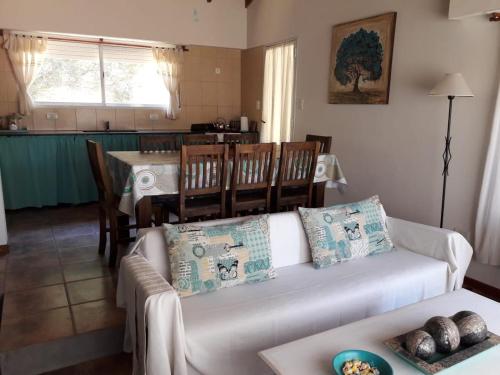 sala de estar con sofá blanco y comedor en Casa Brito, en Monte Hermoso