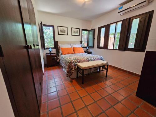 a bedroom with a bed with orange pillows and a table at Villa Arbolada in San Lorenzo