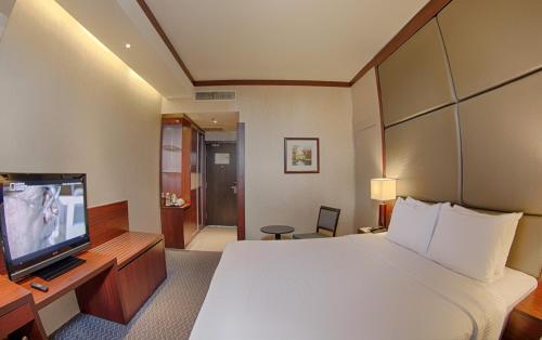 a hotel room with a bed and a flat screen tv at KSL Hotel & Resort in Johor Bahru