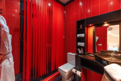 a red bathroom with a toilet and a sink at Riad L'ECOLE in Marrakech