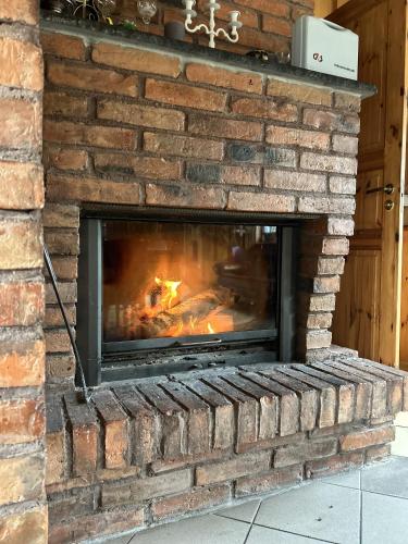 a brick fireplace with a fire in it at Oraveski talu in Lodja