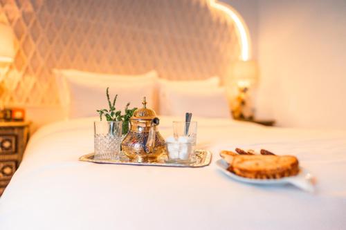 a tray of food and a pastry on a bed at Riad L'ECOLE in Marrakech