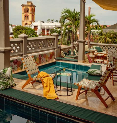 a swimming pool with two chairs and a table at Townhouse Boutique Hotel in Cartagena de Indias