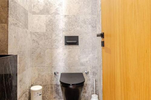 a bathroom with a black toilet and a wall at Luxury 105 Studio in Casablanca