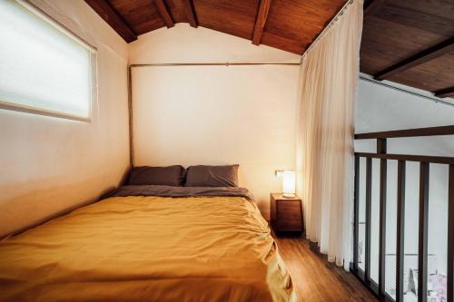 a small bedroom with a bed in a room at LittleDimple b&b小酒窩民宿 in T'ien-liao