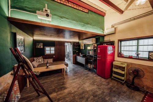 a living room with a red refrigerator and a table at LittleDimple b&b小酒窩民宿 in T'ien-liao