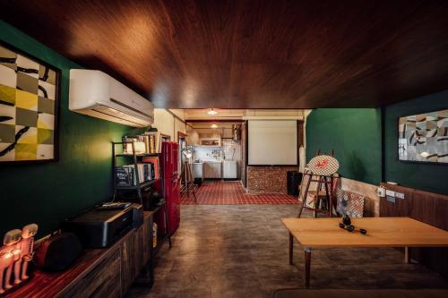 a living room with a green wall and a table at LittleDimple b&b小酒窩民宿 in T'ien-liao