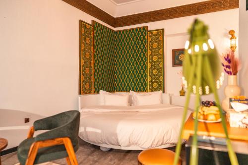 a bedroom with a bed and a desk with a chair at Riad L'ECOLE in Marrakech
