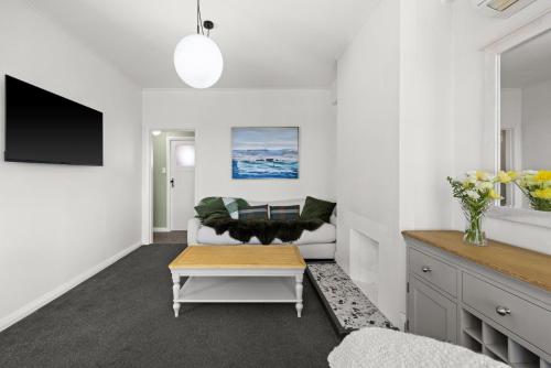 a living room with a couch and a table at Modern Art Deco Cutie in Napier