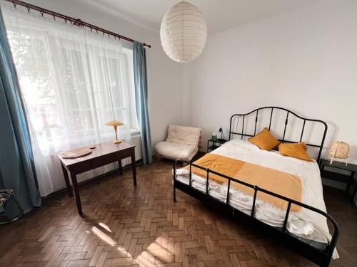 a bedroom with a bed and a table and a window at Spacious Garden Villa in Lublin