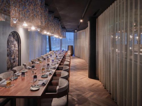 a long dining room with a long table and chairs at Dorint Resort & Spa Locarno-Riazzino in Riazzino