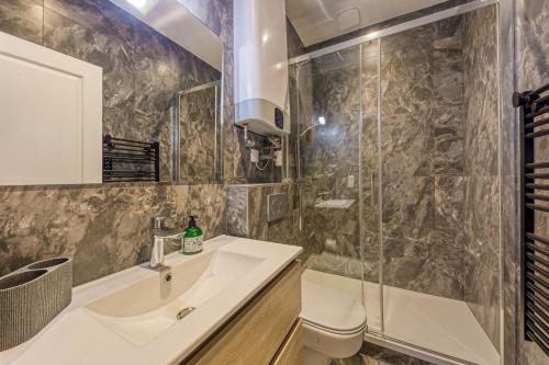 une salle de bain avec un lavabo et une douche dans l'établissement Moderne & Spacieux - Terrasse Privée - Parking Gratuit - 6 Pers, à Montreuil