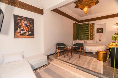 a room with two beds and a table and a bed at Riad L'ECOLE in Marrakech
