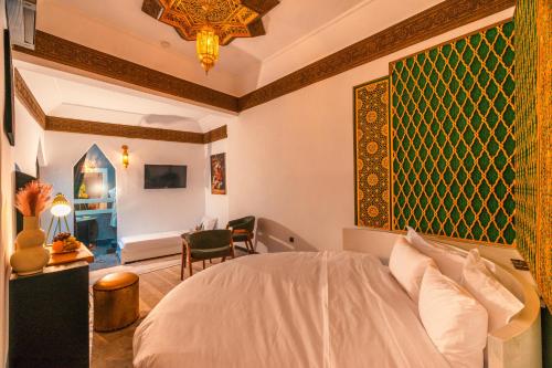 a bedroom with a bed and a table and a chair at Riad L'ECOLE in Marrakech