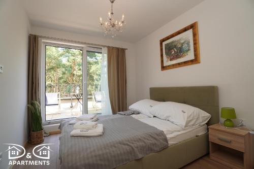 une chambre avec un lit avec deux serviettes dessus dans l'établissement Pine Tree House 10 D&D Apartments, à Międzywodzie