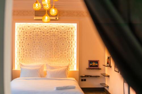 a bedroom with a white bed and a window at Riad L'ECOLE in Marrakech