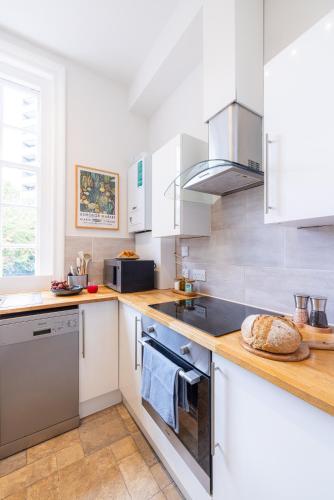 a kitchen with white cabinets and a stove top oven at The Regency by Nestor in London