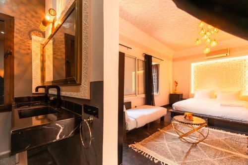 a bathroom with a sink and a bedroom with a bed at Riad L'ECOLE in Marrakech