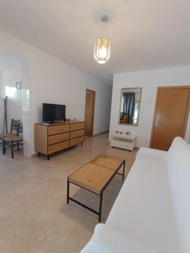 ein Wohnzimmer mit Sofa und Fernseher in der Unterkunft Blue Day Solo Familias in Puerto de Gandía
